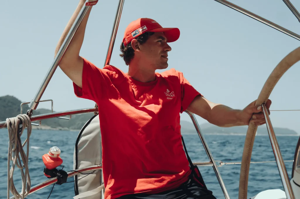 Skipper steering a sailing yacht at sea